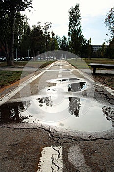 Puddle of water on asphalt and old road