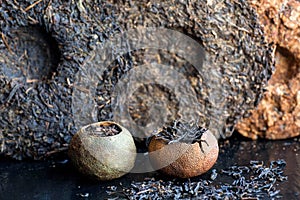 Puer raw tea. Pu-erh in different sorts and shapes. Tea cakes texture and orange tea made in traditional chinese way