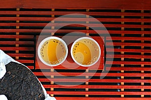 Puer tea. Packed pancake of traditional chinese puer tea with white teaput. Asian pressed pu-erh tea and crockery tea set, clay