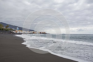 Puerto de la Cruz, Tenerife, Canary Islands - view of colorful houses, sea and volcanic-sand beach. Black beach in tenerife