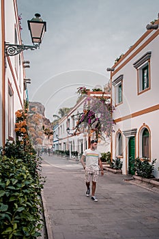 Puerto de Mogan Gran Canaria, colorful harbor village Gran Canaria, young men walking whitewashed colorful village