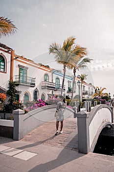 Puerto de Mogan Gran Canaria, colorful harbor village Gran Canaria, young woman walking whitewashed colorful village