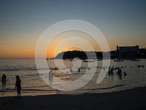 Puerto Escondido, Oaxaca, Mexico, South America: [Sunset at the local beach, lighthouse, crowdwed beach, tourist destination]