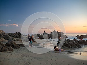 Puerto Escondido, Oaxaca, Mexico, South America: [Sunset at the local beach, lighthouse, crowdwed beach, tourist destination]