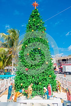 Puerto Morelos, Mexico - January 10, 2018: Outdoor view of a huge christmast tree with a manger in the base in the park