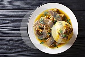 Puerto Rican Mofongo made from plantains, garlic and chicharron served with meat and broth close-up. horizontal top view