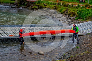 PUERTO VARAS, CHILE, SEPTEMBER, 23, 2018: Unidentified group of men holding a kayack in their hands in Puerto Varas