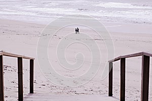 dos personas paseando por la playa photo