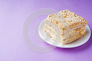 Puff cake with cream Napoleon Millefeuille vanilla slice color on purple background