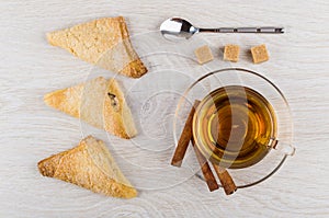 Puff cookies, tea, cinnamon on saucer, spoon, sugar cubes