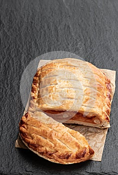 Puff pastry cheese and baked bean pie on black stone background