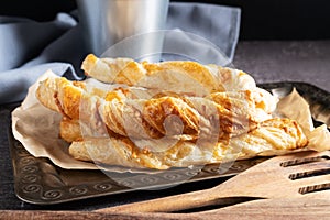 Puff pastry cheese sticks on a silver tray close-up