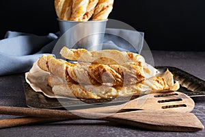 Puff pastry cheese sticks on a silver tray next to baking accessories