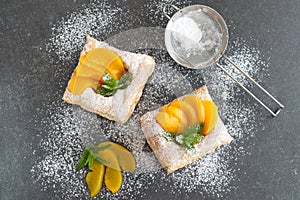 Puff pastry cookies with chocolade cream and tinned apricots