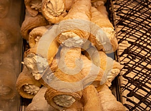 Puff pastry horn with white cream or vla susu. Puff horn filled with white cream on a mirror background close-up