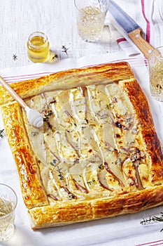 Puff pastry pie with cheese, pears, nuts and honey, served with champagne.