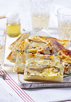 Puff pastry pie with cheese, pears, nuts and honey, served with champagne.