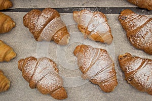 Puff pastry rolls. fresh sweet baking on papyrine. Several kinds of crispy pies lie in rows on a baking sheet on the counter. Top photo