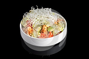 Puff salad with shrimp, avocado and tomato, seasoned with yogurt sauce on plate. restaurant dish on a black background