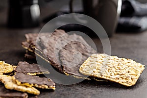 Puffed corn crackers chocolate covered on black table