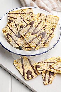 Puffed corn crackers chocolate covered on white table