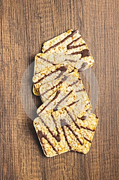 Puffed corn crackers chocolate covered on wooden table