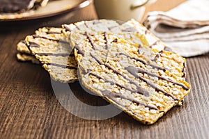 Puffed corn crackers chocolate covered on wooden table