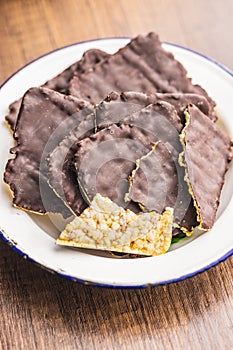 Puffed corn crackers chocolate covered on wooden table