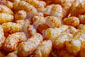 Puffed corn peanuts snacks on plate. Close-up.