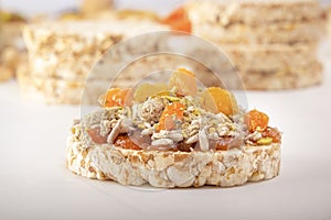 Puffed exploded wheat grains with peeled sunflower seeds, halva and raisins on a thin layer of apricot jam on