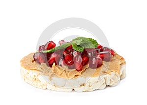 Puffed rice cake with peanut butter, pomegranate seeds and mint isolated