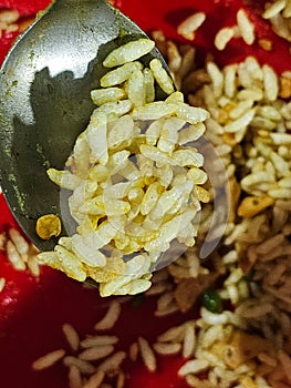 Puffed rice with mixed spices are tasty snack food. It is close image at spoon with food