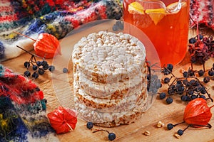 Puffed wheat cake and red tea with lemon. Wild forest berries, physalis on a wooden table