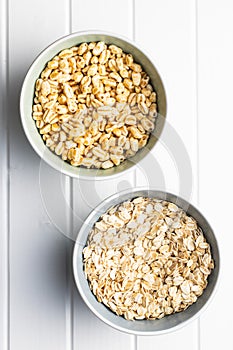 Puffed wheat covered with honey and oatmeals in bowls