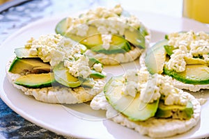 Puffed wheat toast with avocado and fresh cheese with olive oil and parsley