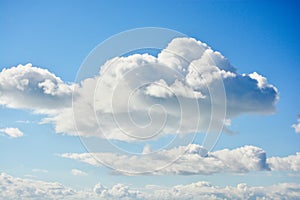 Puffy cumulous clouds billowing across a blue sky