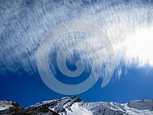 Puffy mountains under feathery clouds