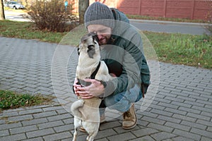 Pug dog licks human owner face. Man with his dog playing and having fun in the park. Concepts of friendship with pets