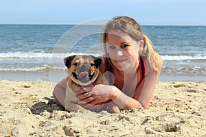 Pug Dog and owner on a sunny beach