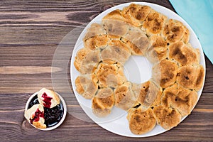 Pull apart monkey bread with black currant jam in a plate on a wooden plate