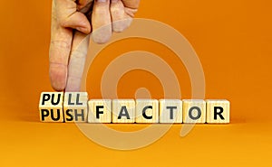 Pull or push factor symbol. Concept word Pull factor and Push factor on wooden cubes. Beautiful orange table orange background.