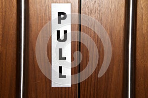 A pull sign on a door in a public building.
