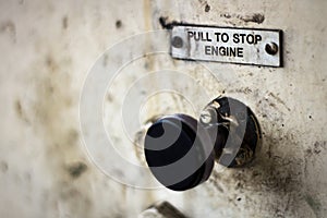 Pull to stop engine sign above a pull control.  Mucky and greasy heritage sign