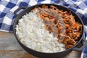 Pulled pork with long-grain basmati rice in iron stewpot