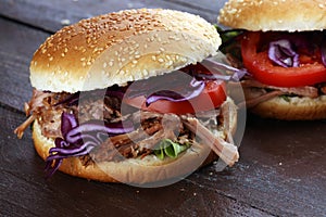 Pulled pork sandwiches with BBQ sauce, cabbage and tomato on tab