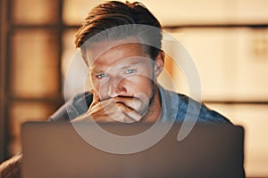 Pulling an all-nighter to complete a project. a handsome young man looking thoughtful while working late in his office. photo