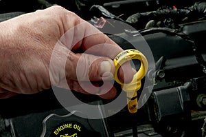 Pulling the dipstick to check oil level