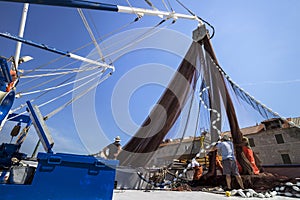 Fishermen arrange net on ship deck