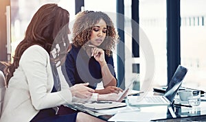 Pulling off productivity with all the right apps. two businesswomen using a digital tablet together during a