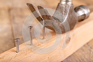 Pulling out nails from a piece of wood using a carpenter& x27;s hammer. Small carpentry work in the workshop photo